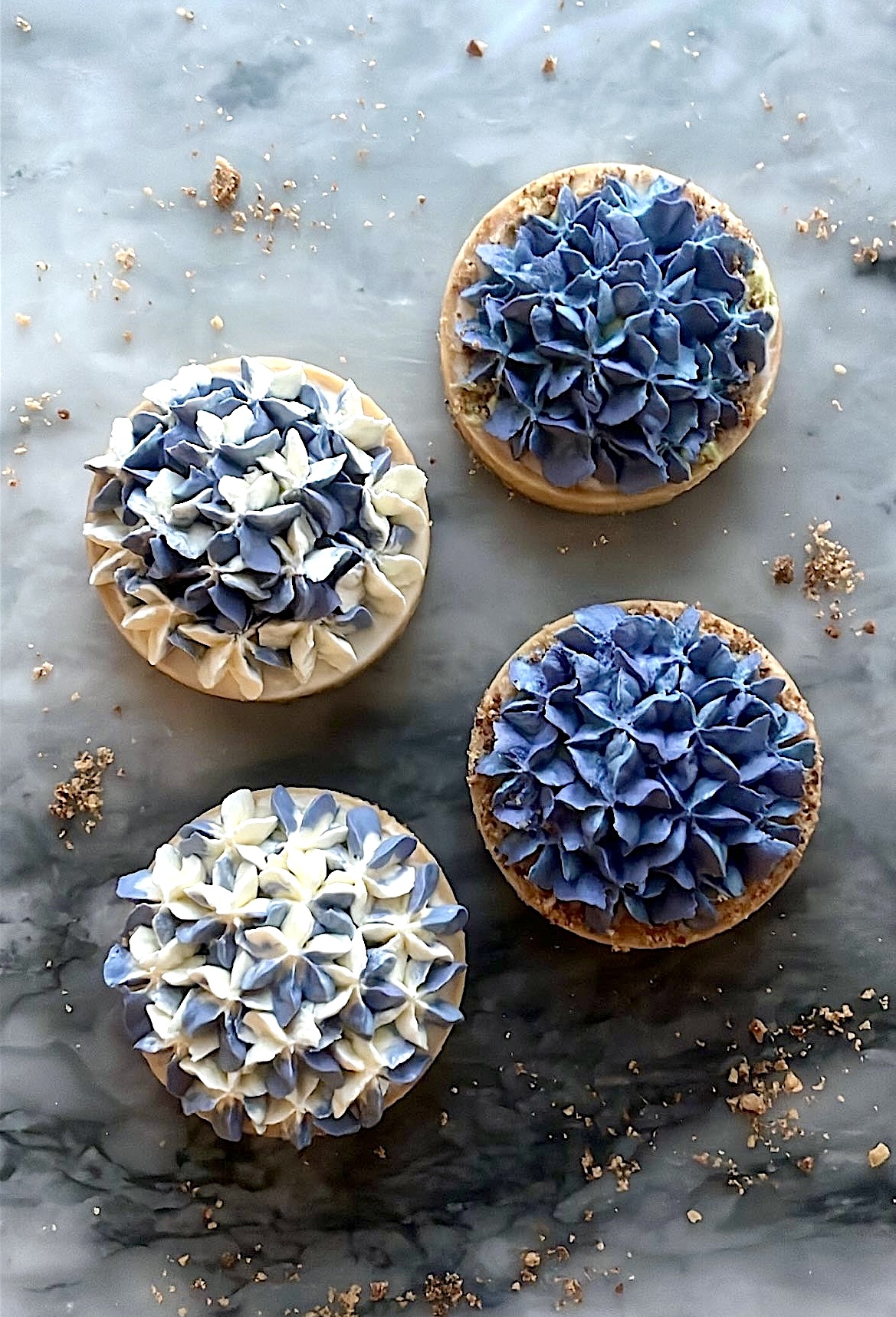 Tart topped with hydrangea-shaped cream decoration in a mix of white and blue colors